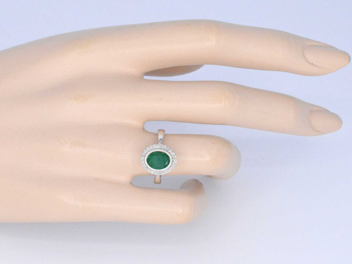 Witgouden entourage ring met diamanten en smaragd