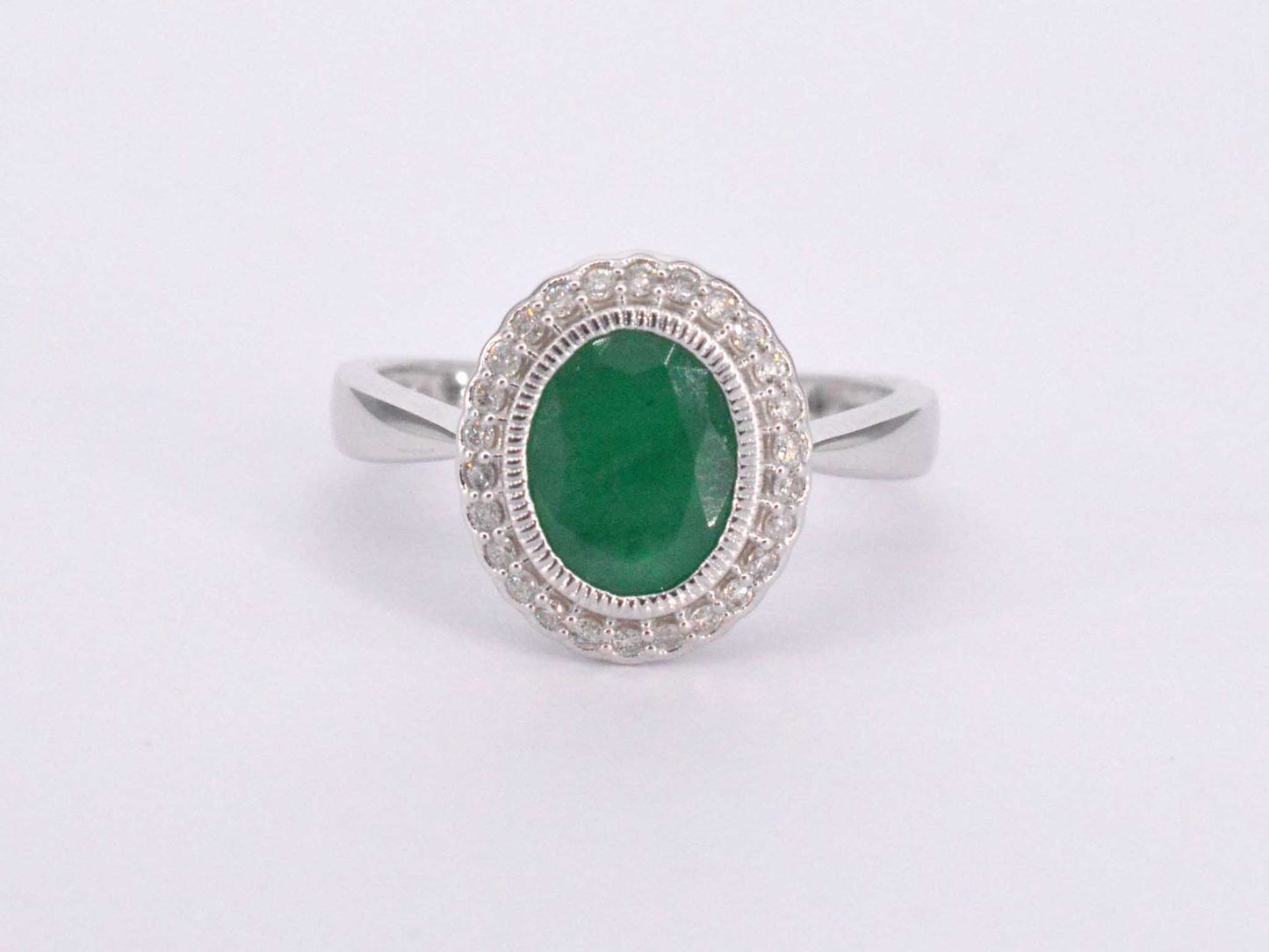 Witgouden entourage ring met diamanten en smaragd