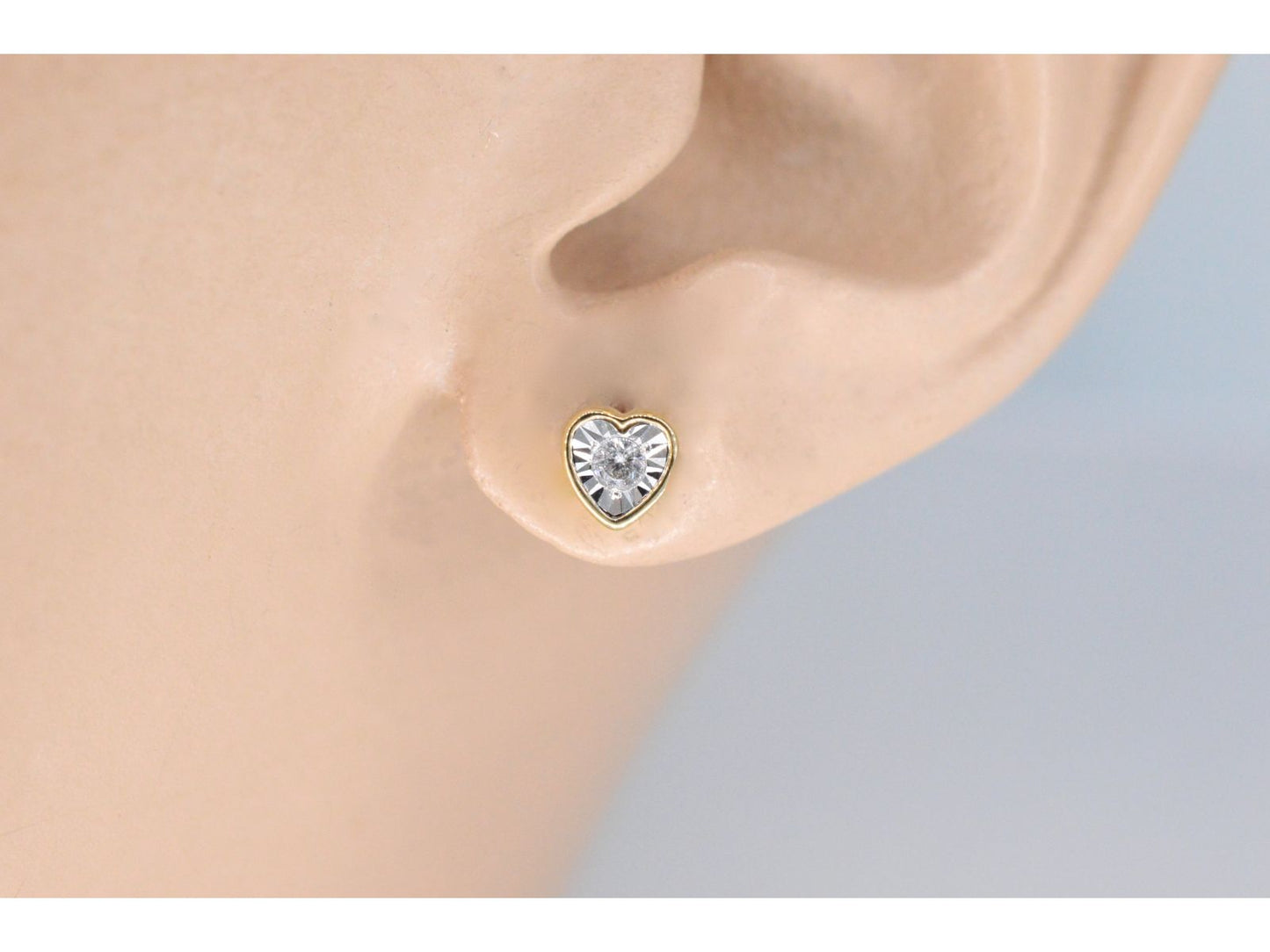Gouden oorbellen met een briljant geslepen diamant in hartvorm