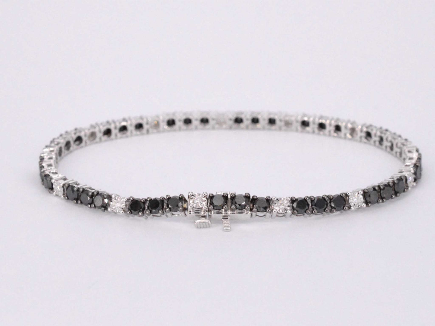 Witgouden tennisarmband rondom gezet met zwarte en witte diamanten