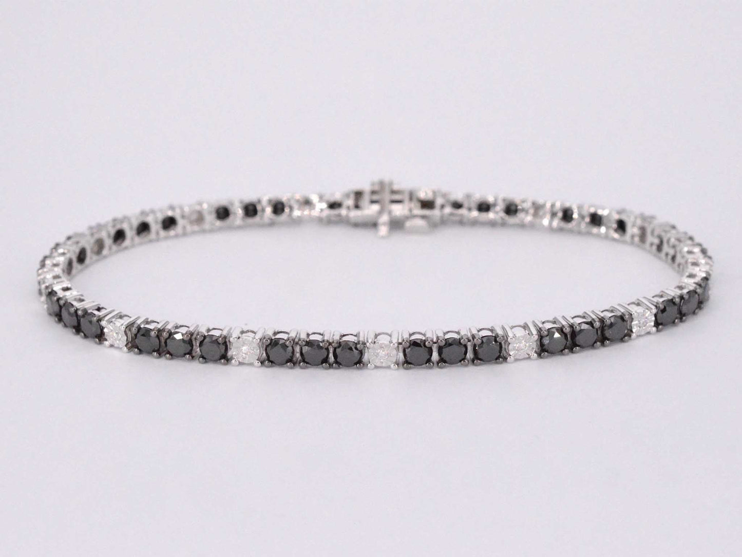 Witgouden tennisarmband rondom gezet met zwarte en witte diamanten