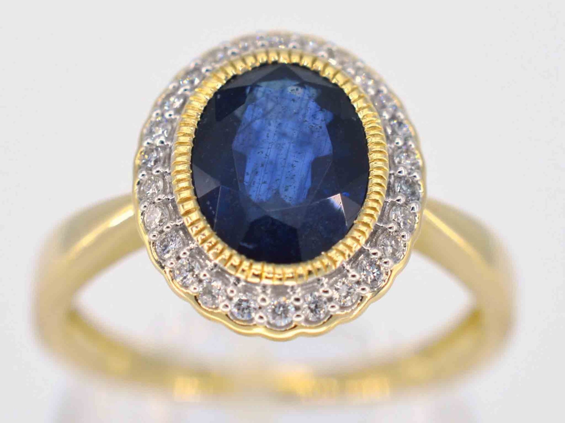 Gouden entourage ring met diamanten en saffier