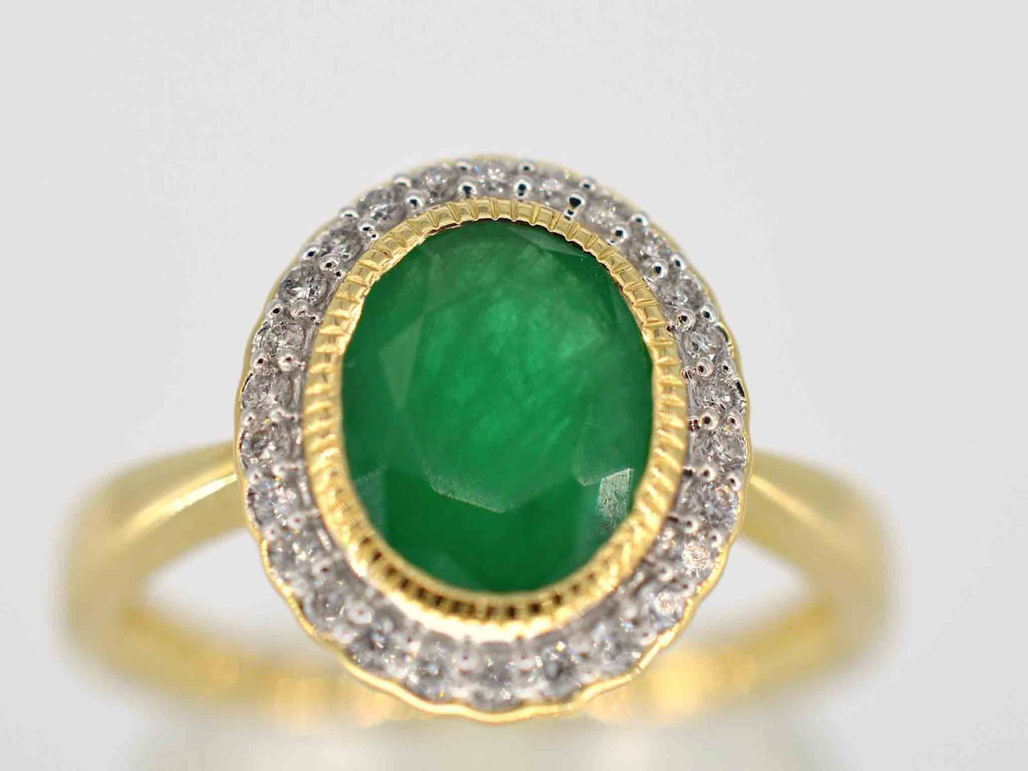 Gouden entourage ring met diamanten en smaragd