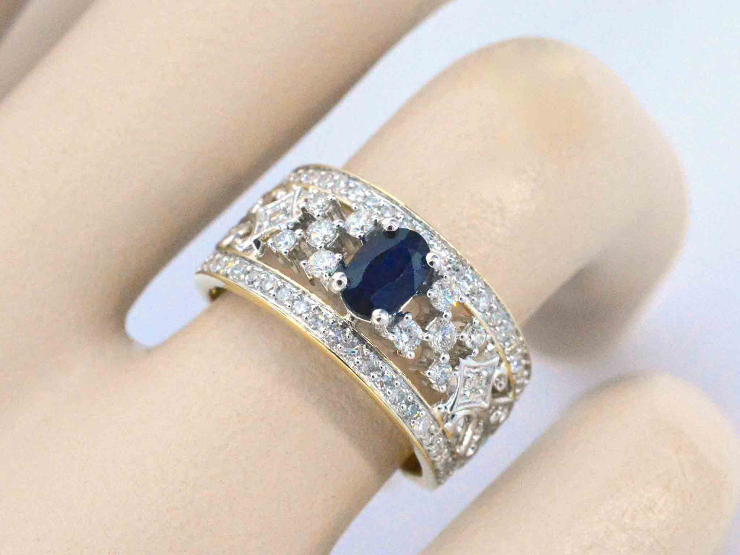 Gouden exclusieve ring vol met diamanten en een saffier