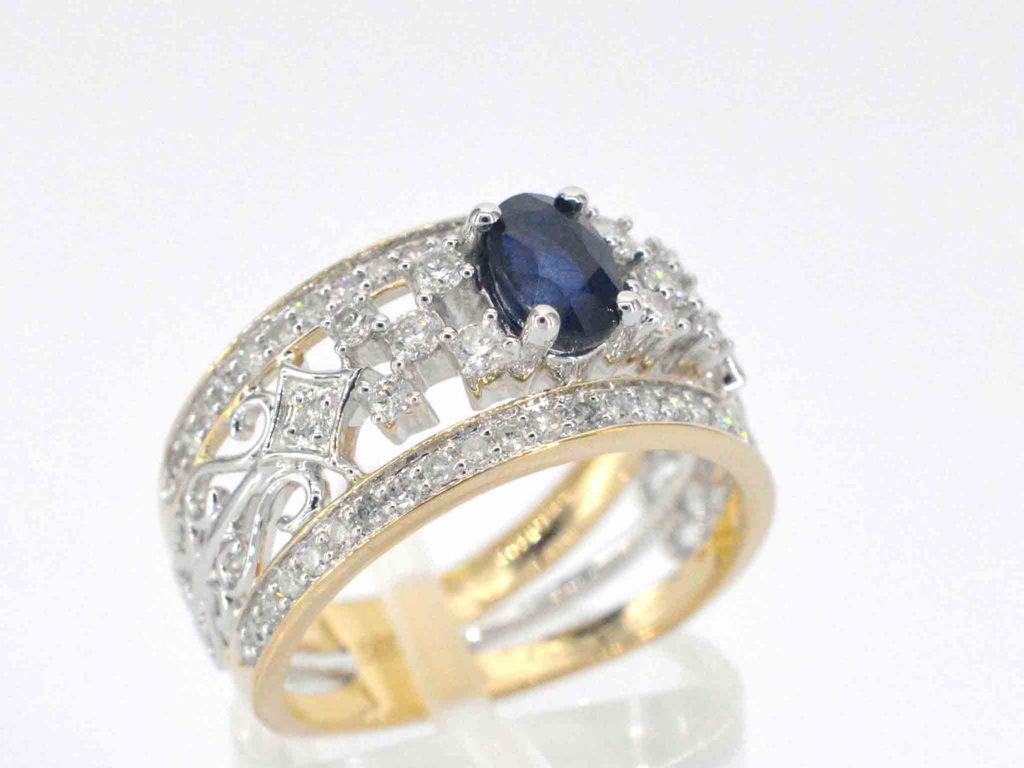 Gouden exclusieve ring vol met diamanten en een saffier