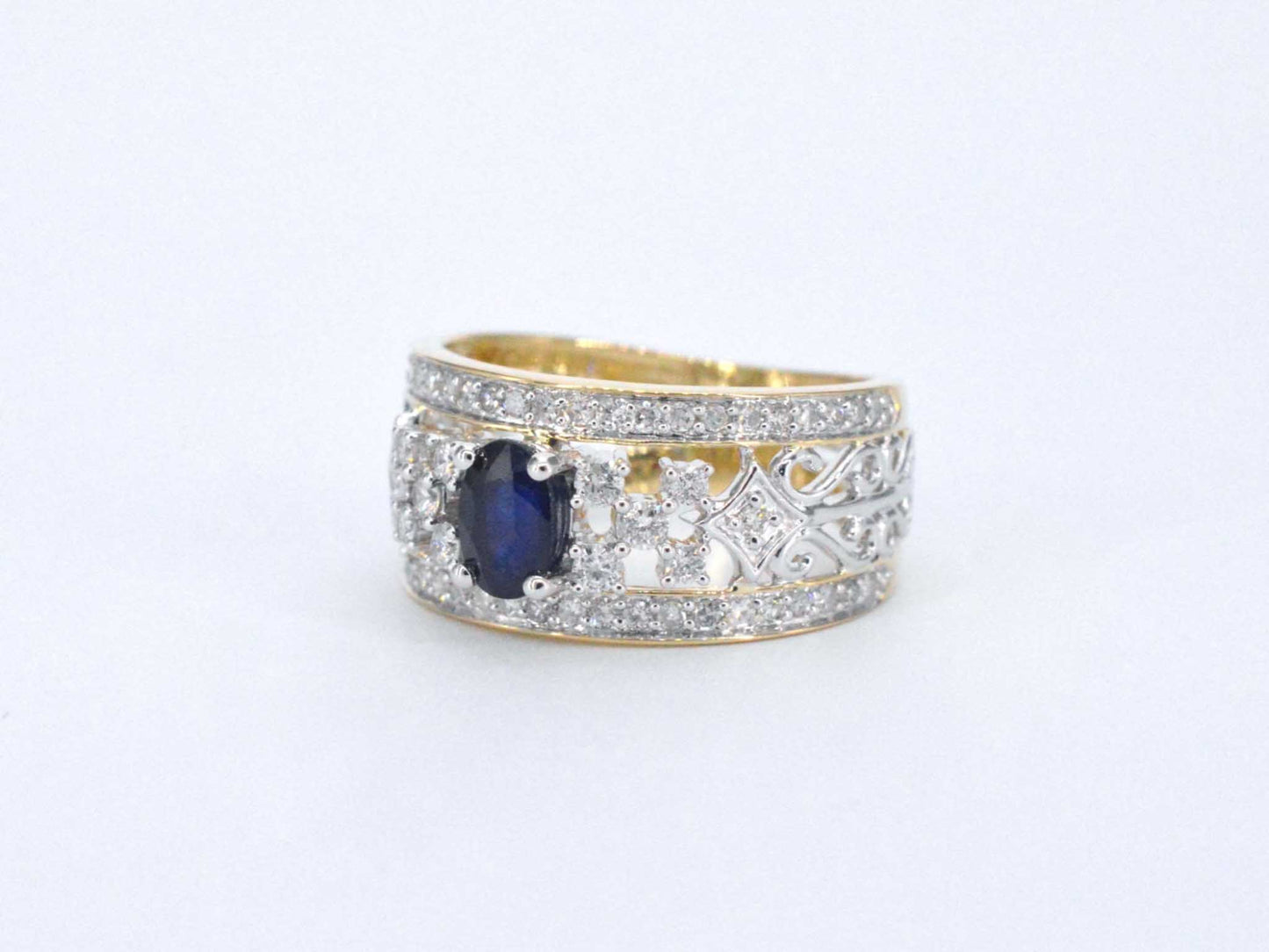 Gouden exclusieve ring vol met diamanten en een saffier