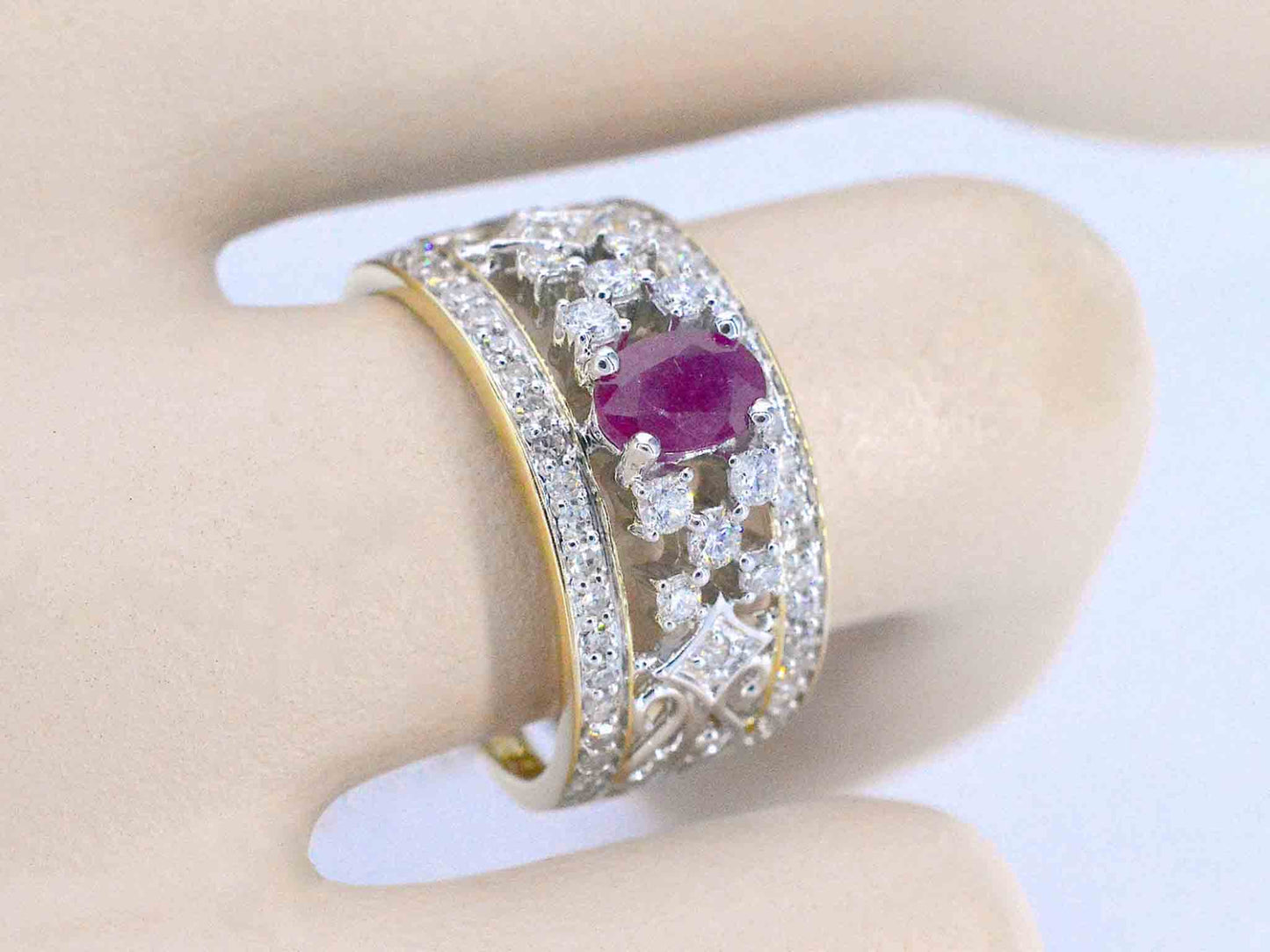 Gouden exclusieve ring vol met diamanten en een robijn