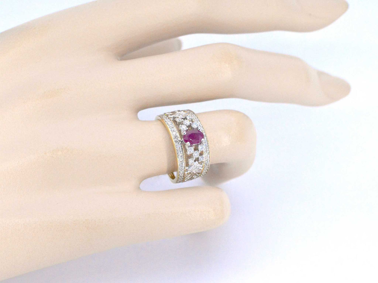 Gouden exclusieve ring vol met diamanten en een robijn