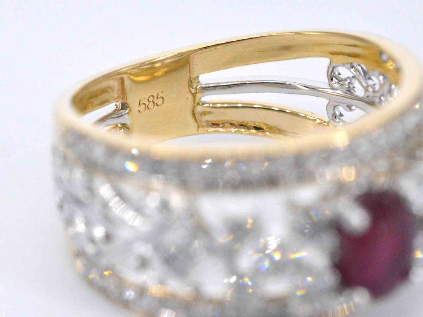 Gouden exclusieve ring vol met diamanten en een robijn