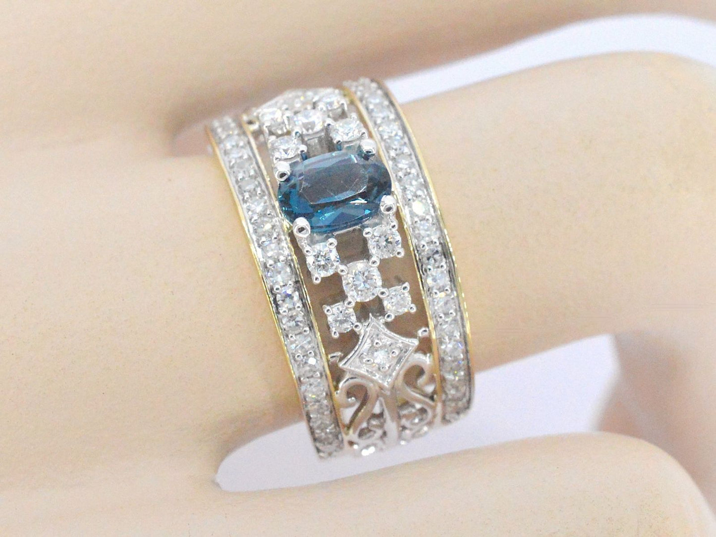 Gouden exclusieve ring vol met diamanten en een edelsteen