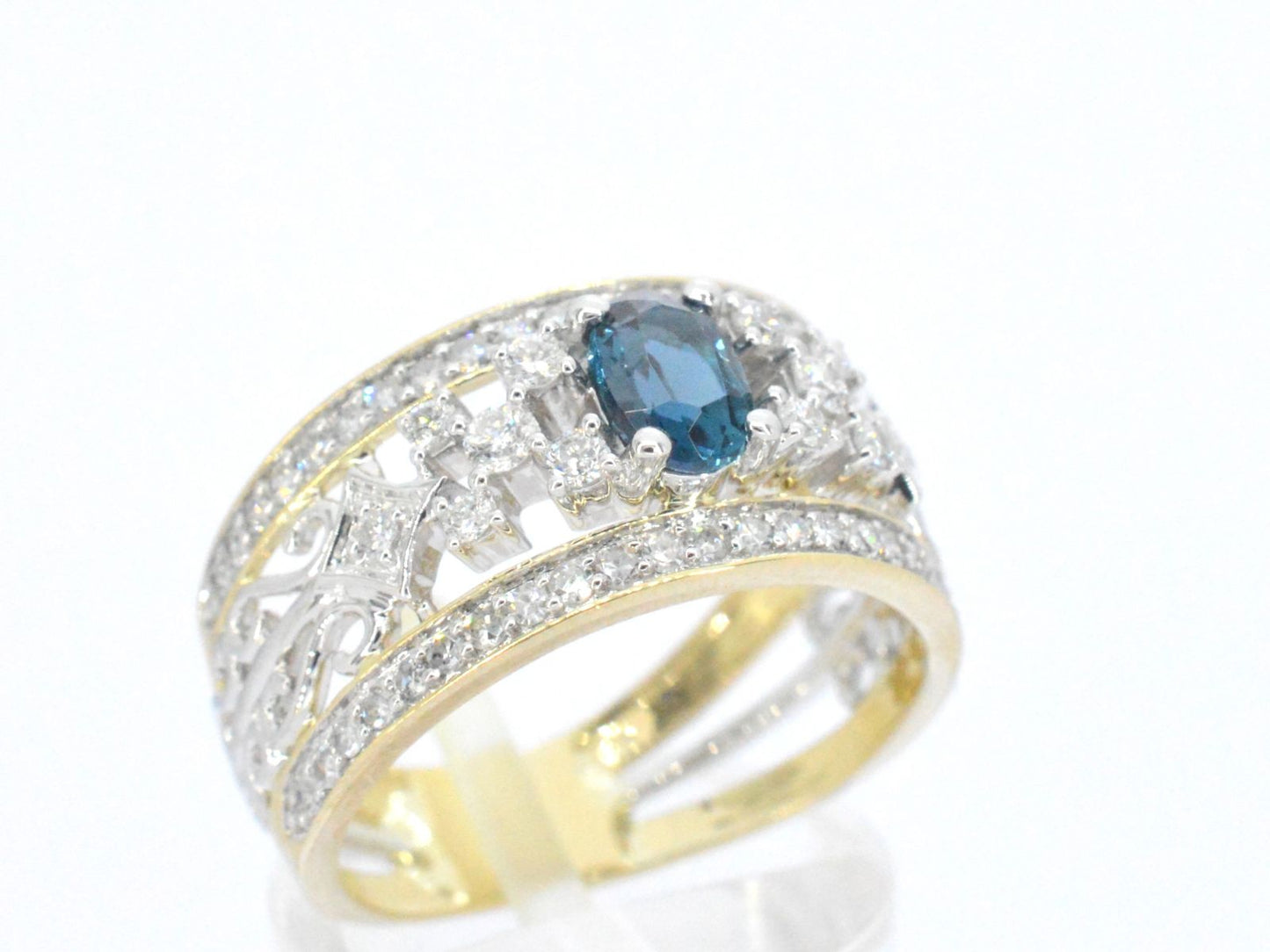 Gouden exclusieve ring vol met diamanten en een edelsteen