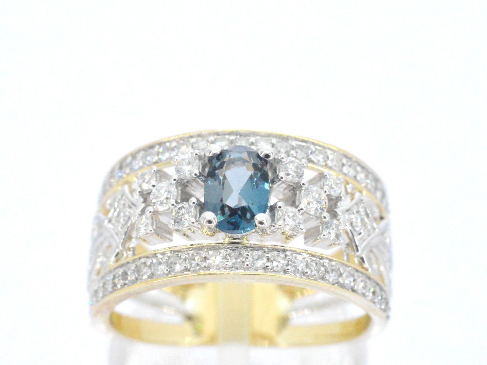 Gouden exclusieve ring vol met diamanten en een edelsteen