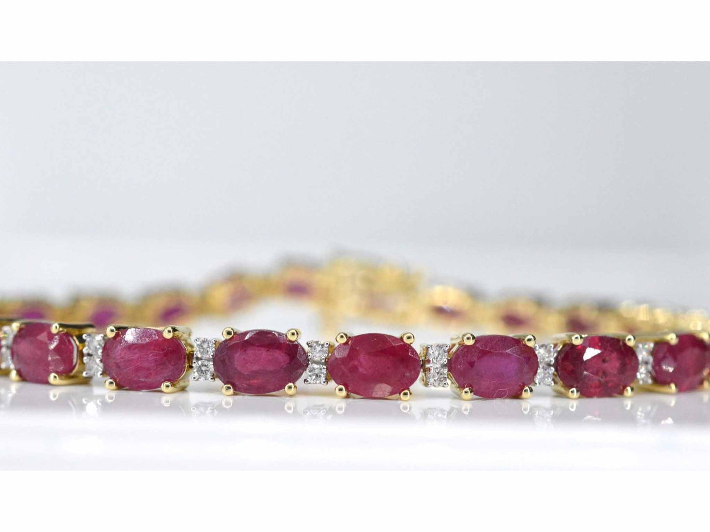 Geelgouden tennisarmband met diamanten en robijn