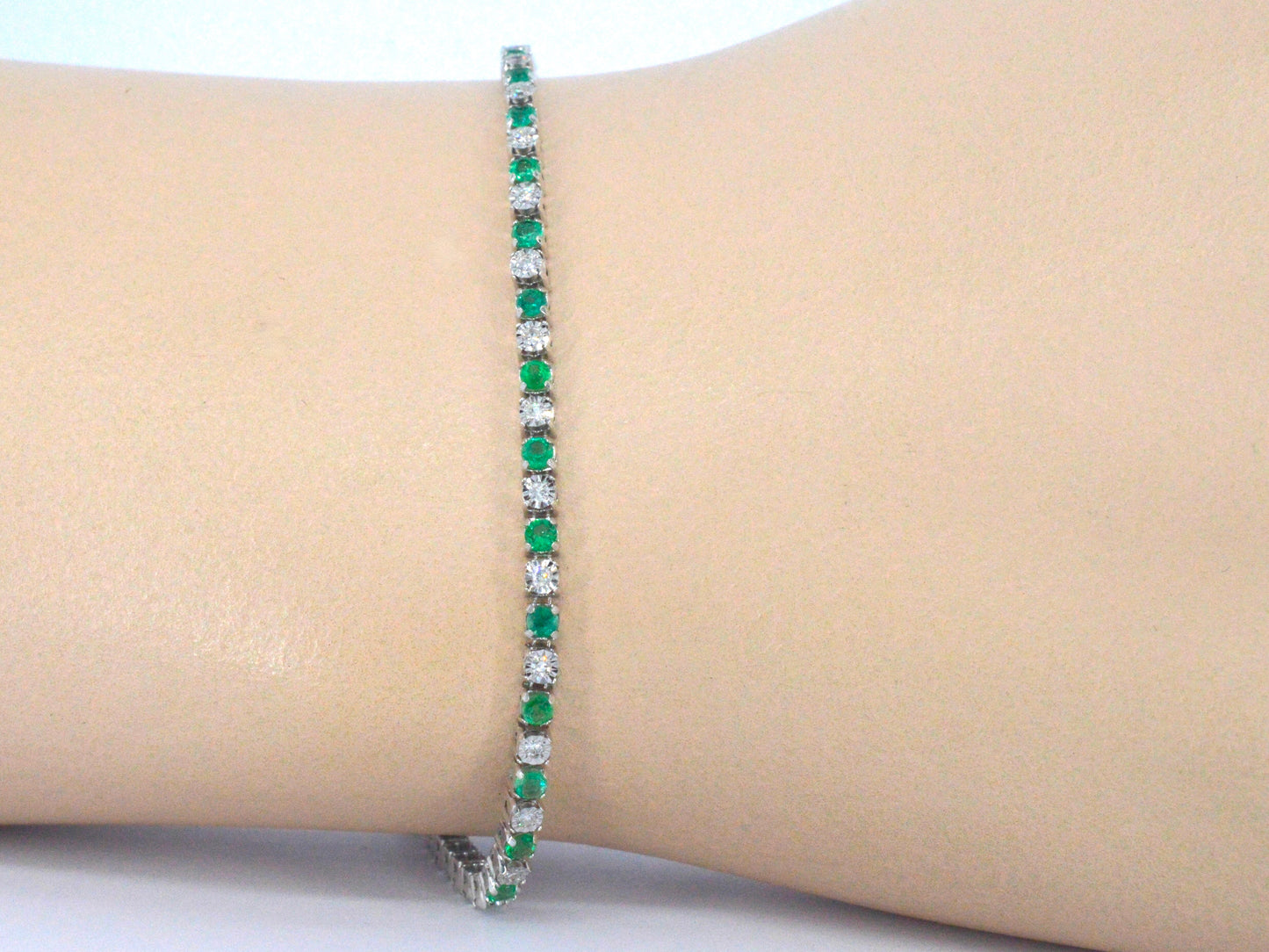 Witgouden tennisarmband met diamanten en smaragden