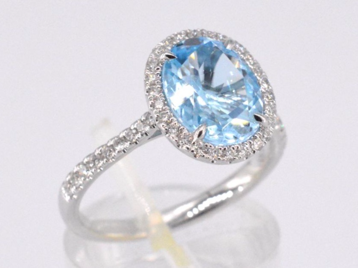 White gold entourage ring with oval cut topaz