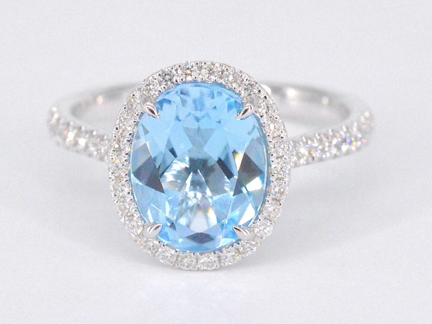 Witgouden entourage ring met ovaal geslepen topaas