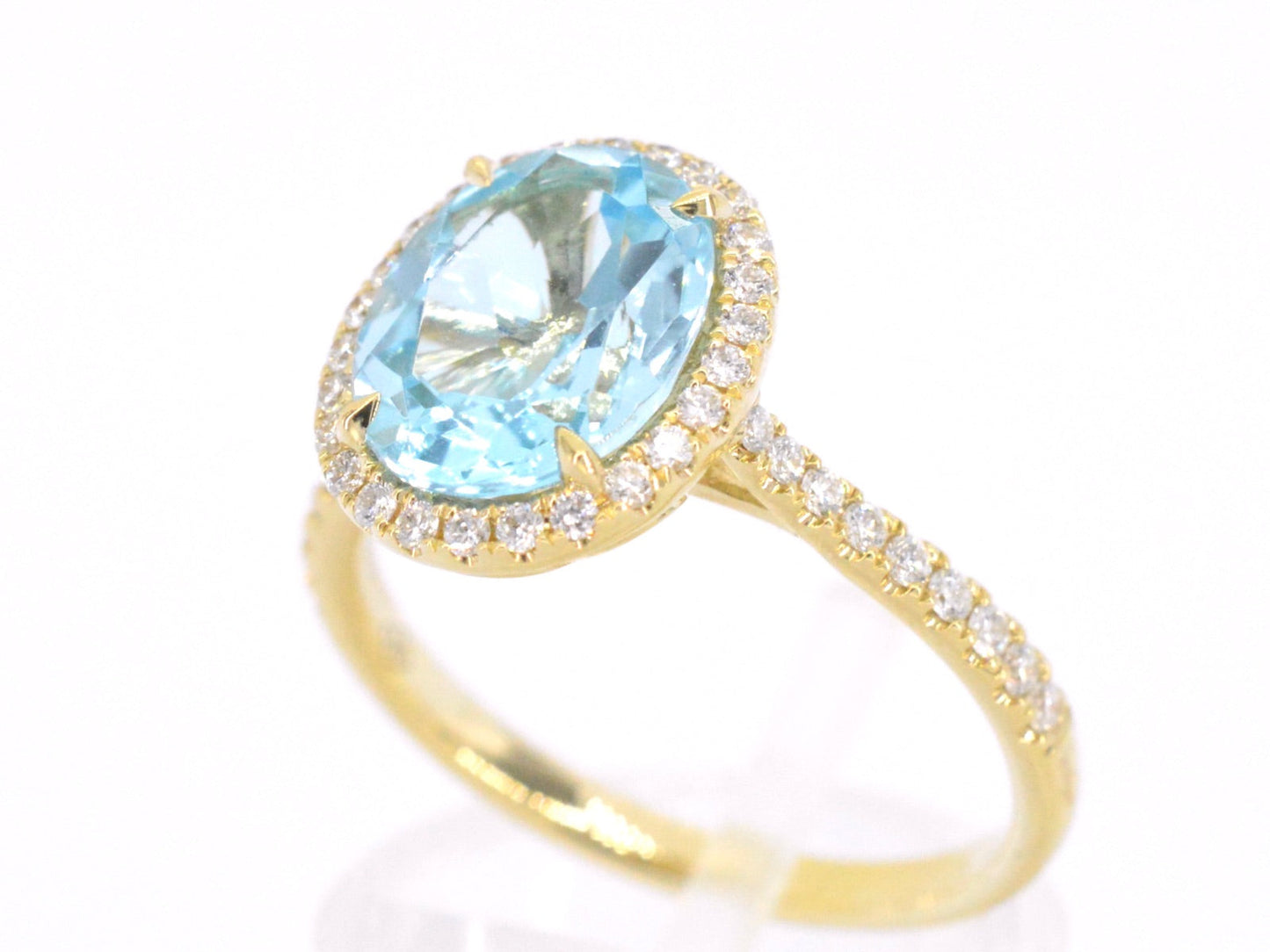 Gold entourage ring with oval cut topaz