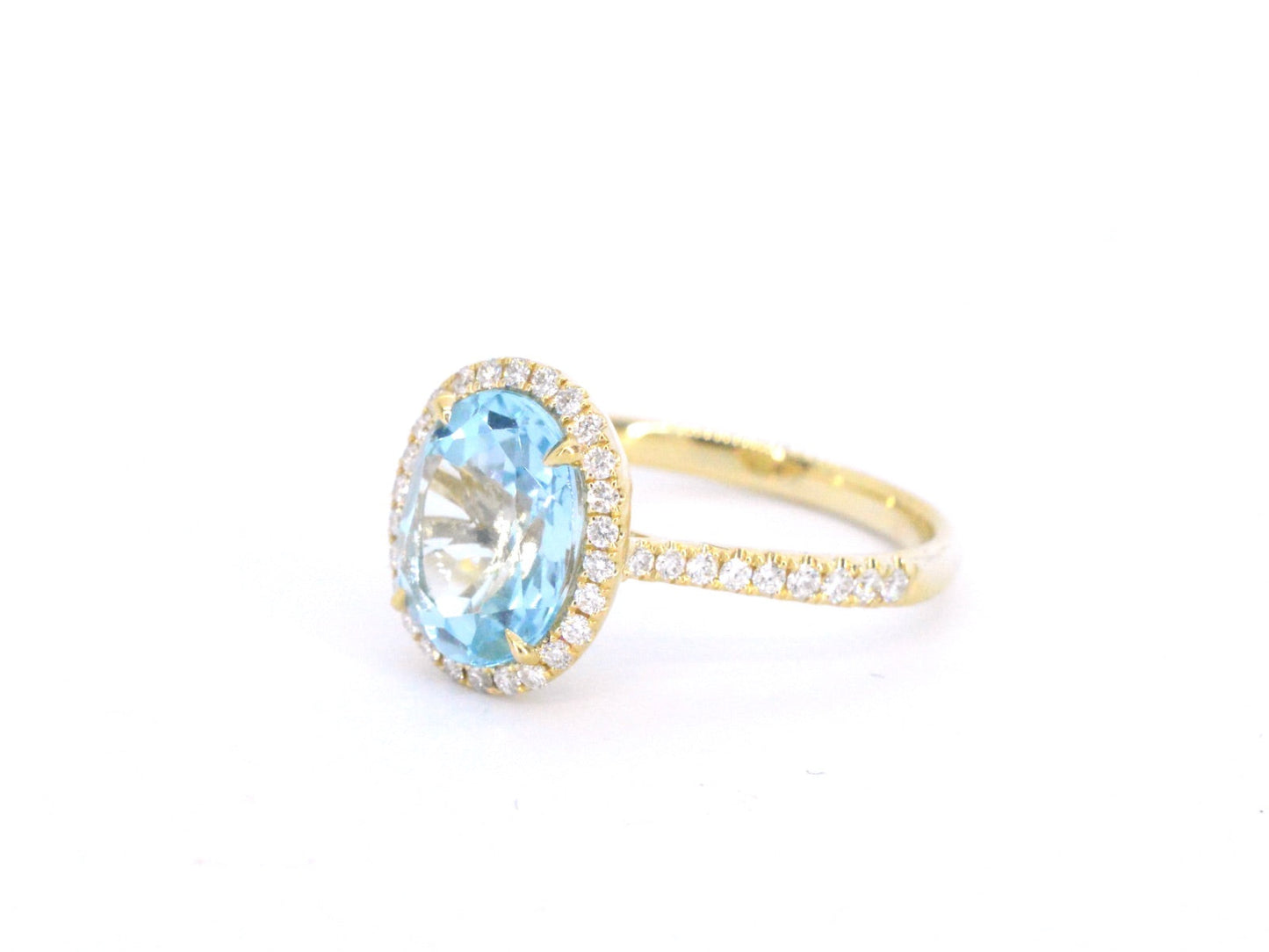 Gold entourage ring with oval cut topaz