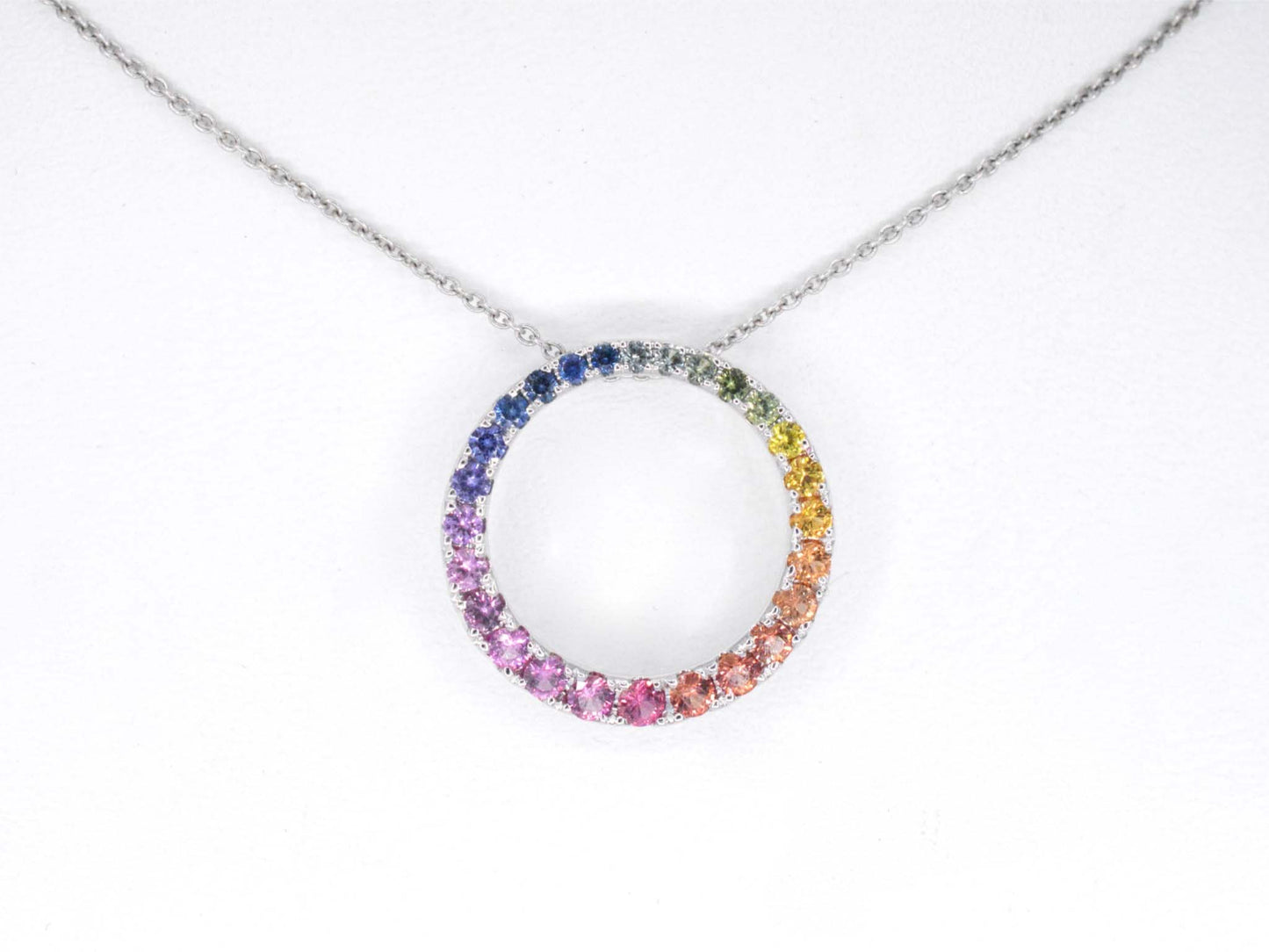 White gold pendant with multi-coloured sapphires set in a circle