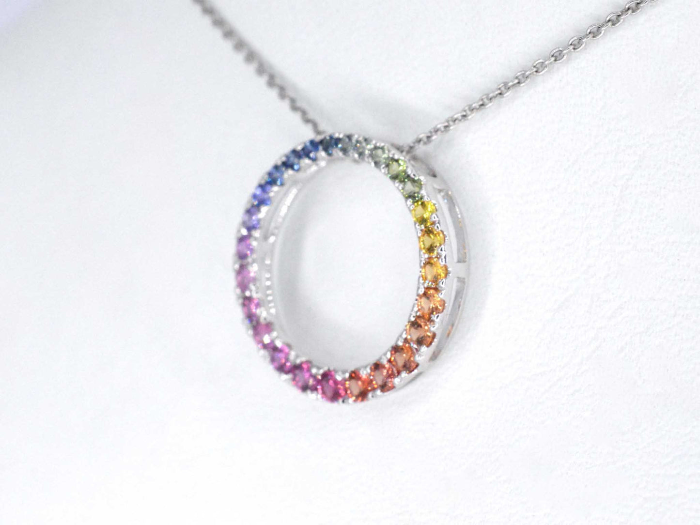 White gold pendant with multi-coloured sapphires set in a circle