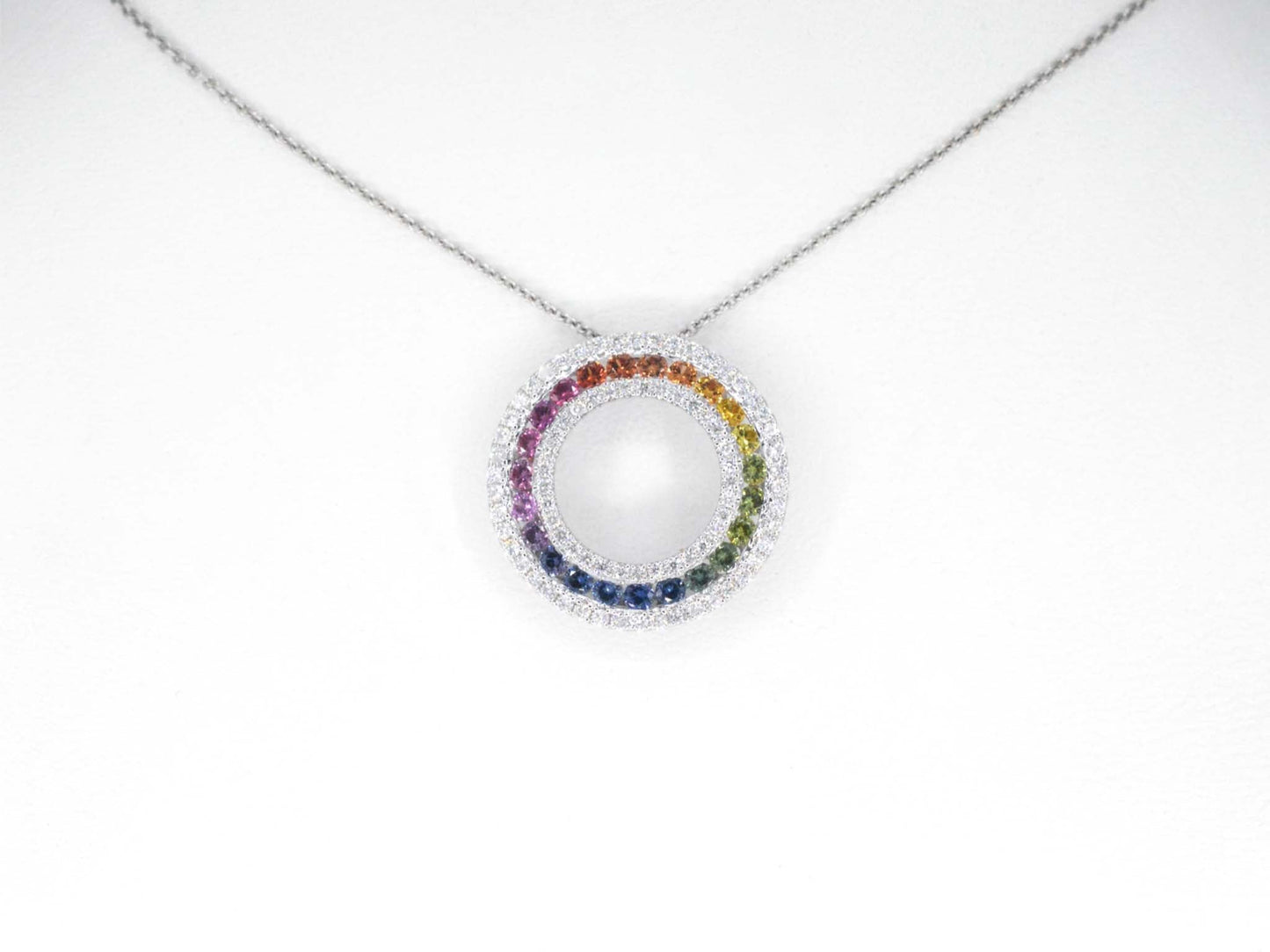 White gold pendant with multi-colored sapphires and diamonds set in a circle