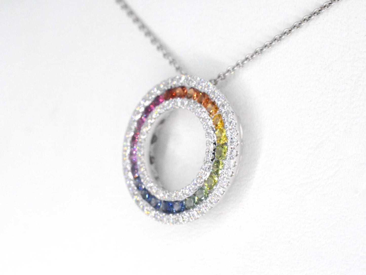 White gold pendant with multi-colored sapphires and diamonds set in a circle