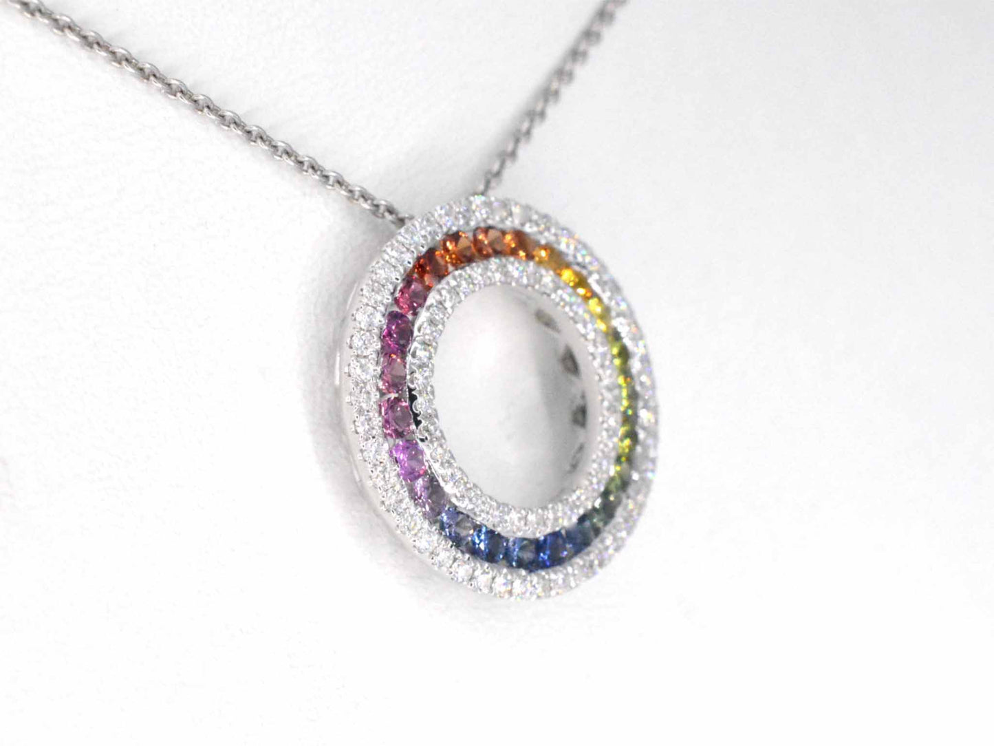 White gold pendant with multi-colored sapphires and diamonds set in a circle