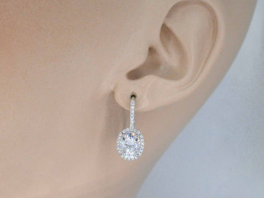 Witgouden entourage oorbellen met diamanten en een gemaakte ovale briljant