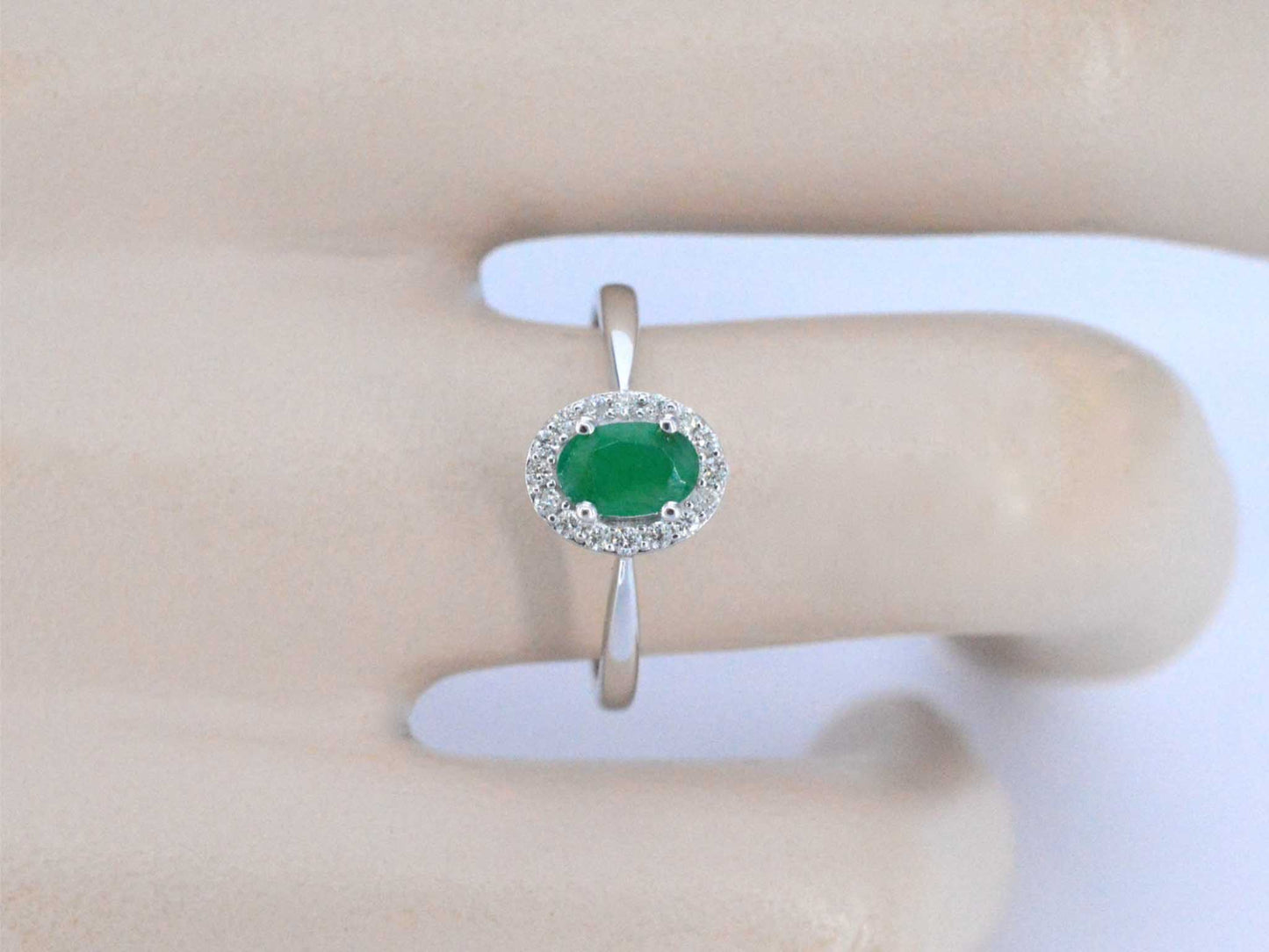 Witgouden entourage ring met diamanten en smaragd