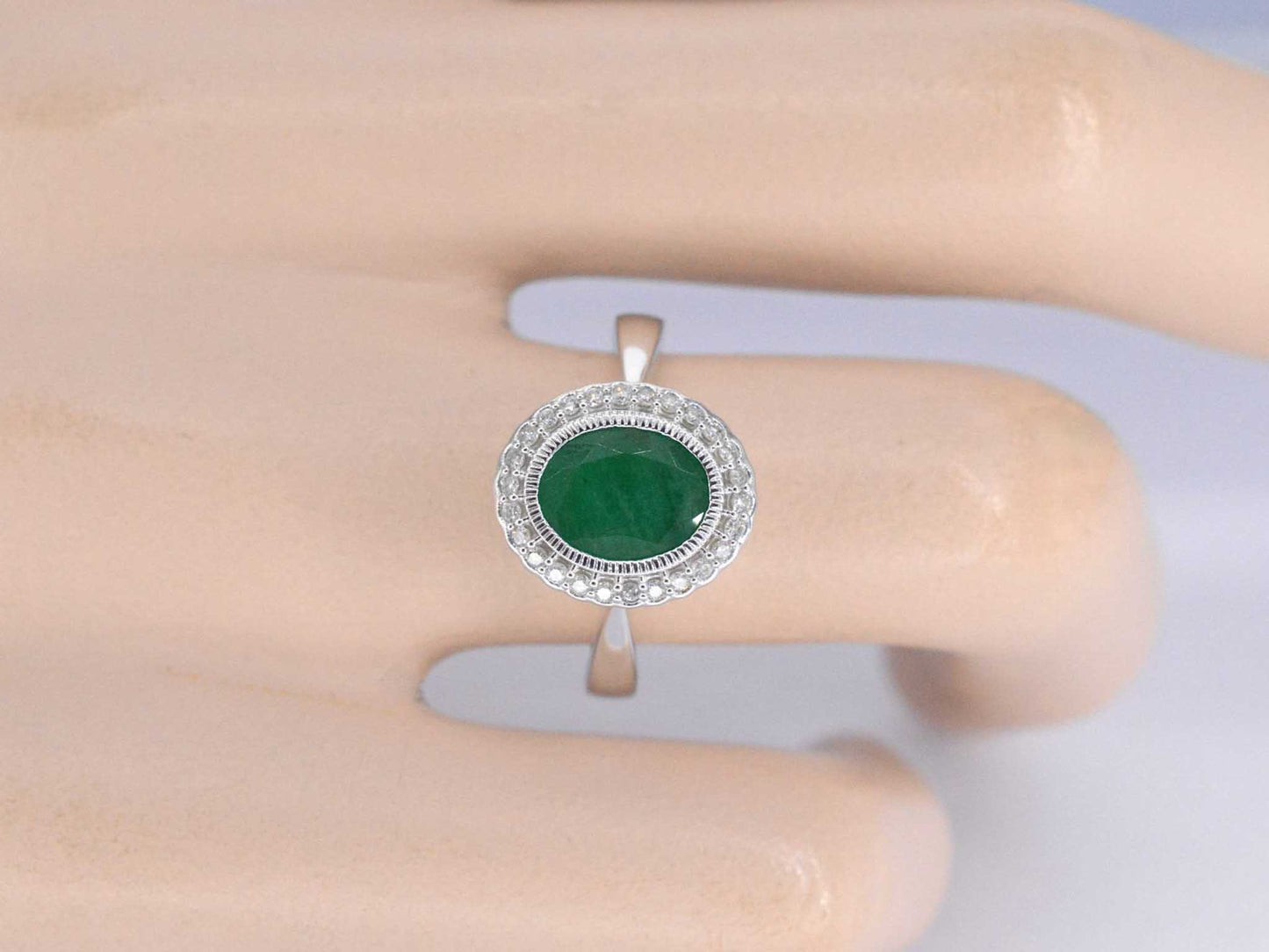 Witgouden entourage ring met diamanten en smaragd