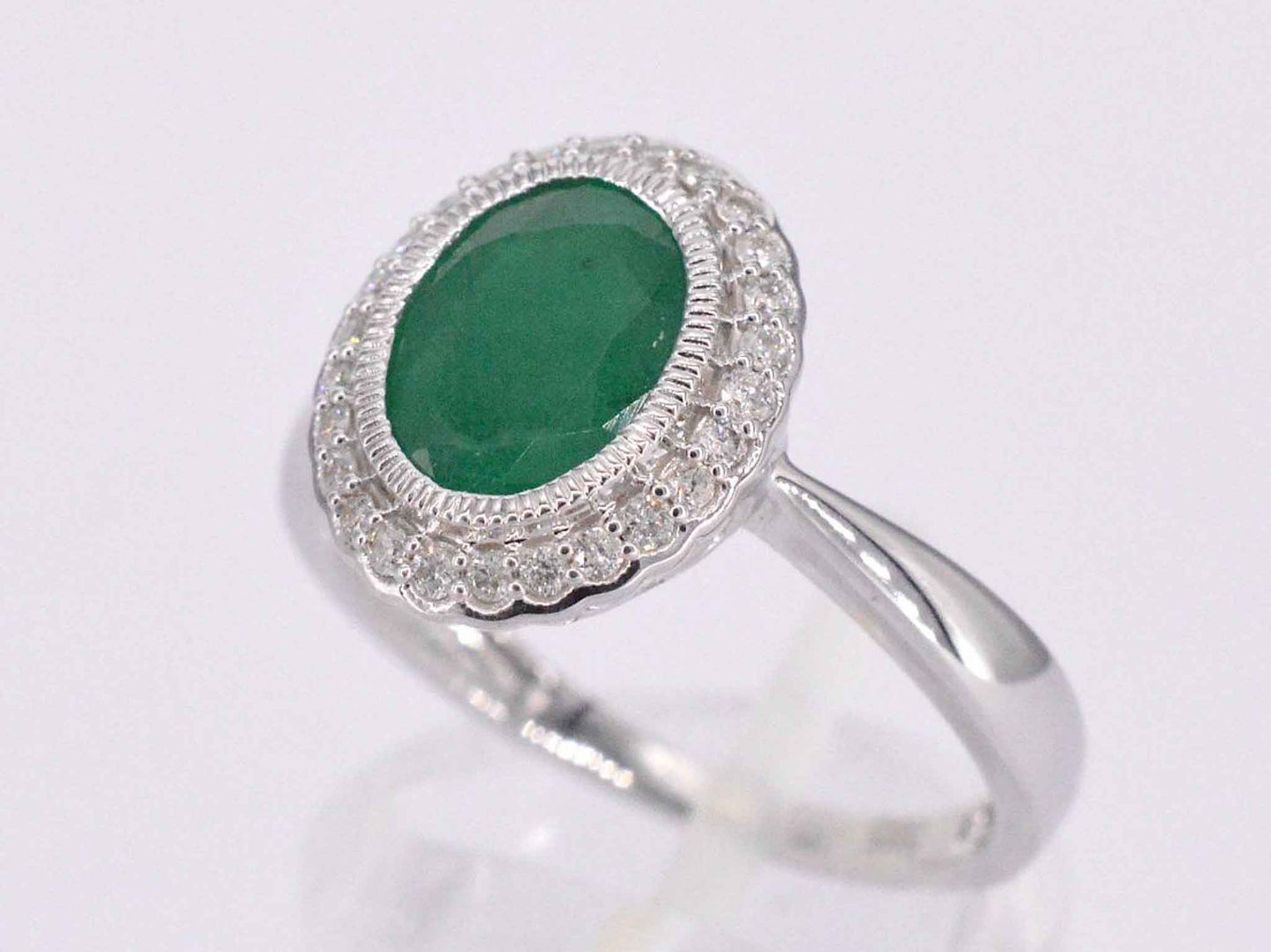 Witgouden entourage ring met diamanten en smaragd
