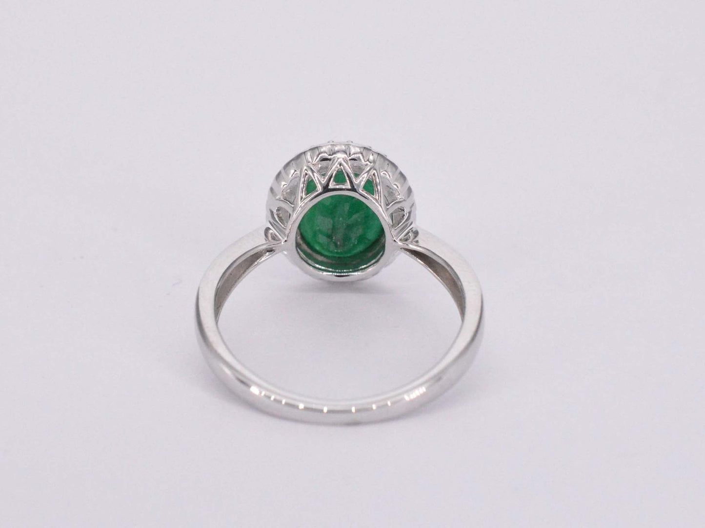 Witgouden entourage ring met diamanten en smaragd