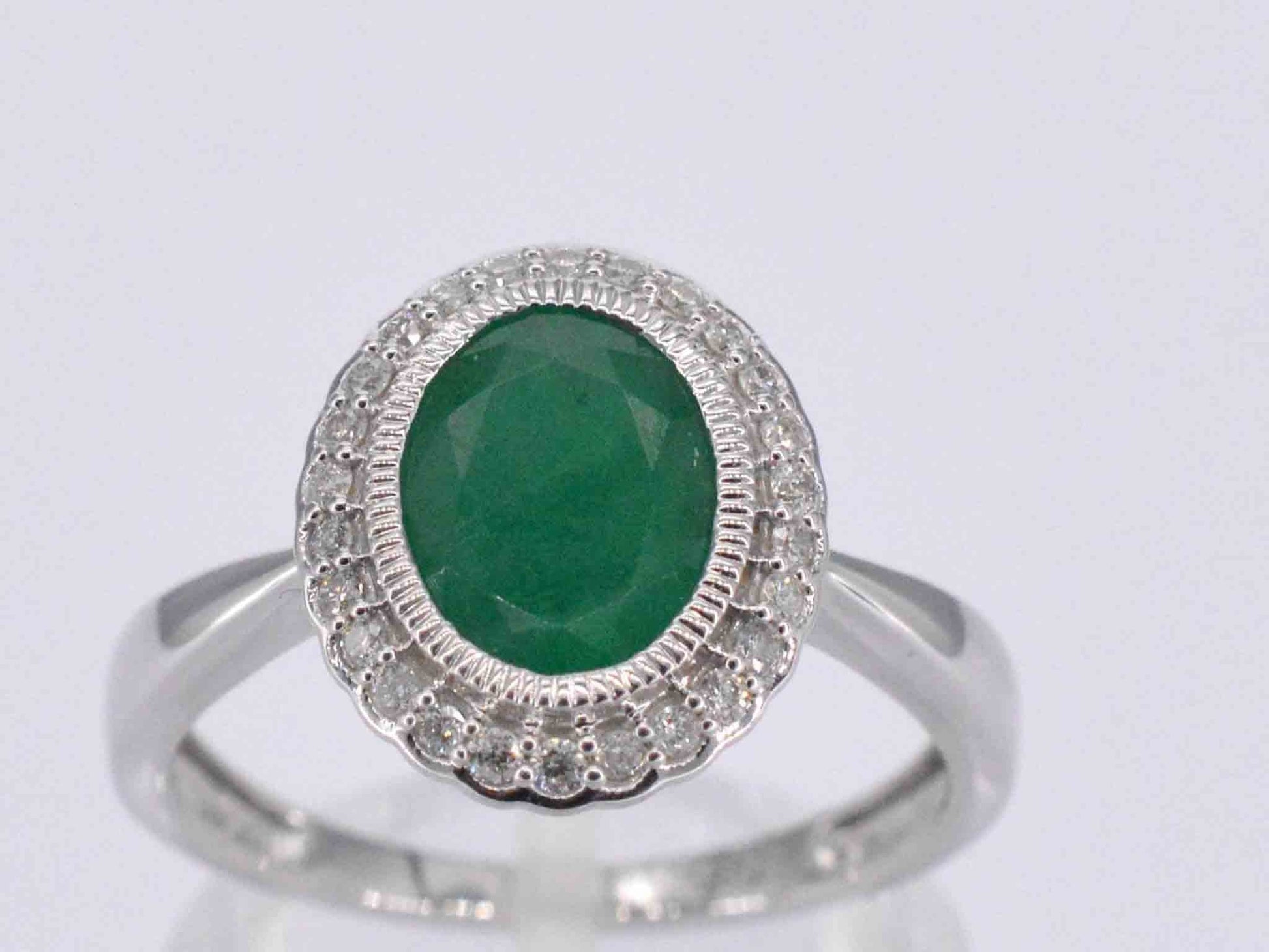 Witgouden entourage ring met diamanten en smaragd