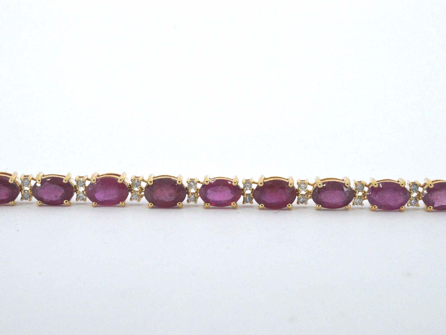 Gouden tennisarmband met diamanten en robijn