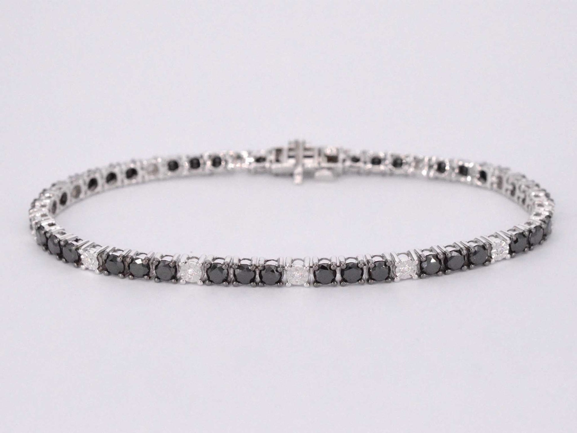 Witgouden tennisarmband rondom gezet met zwarte en witte diamanten