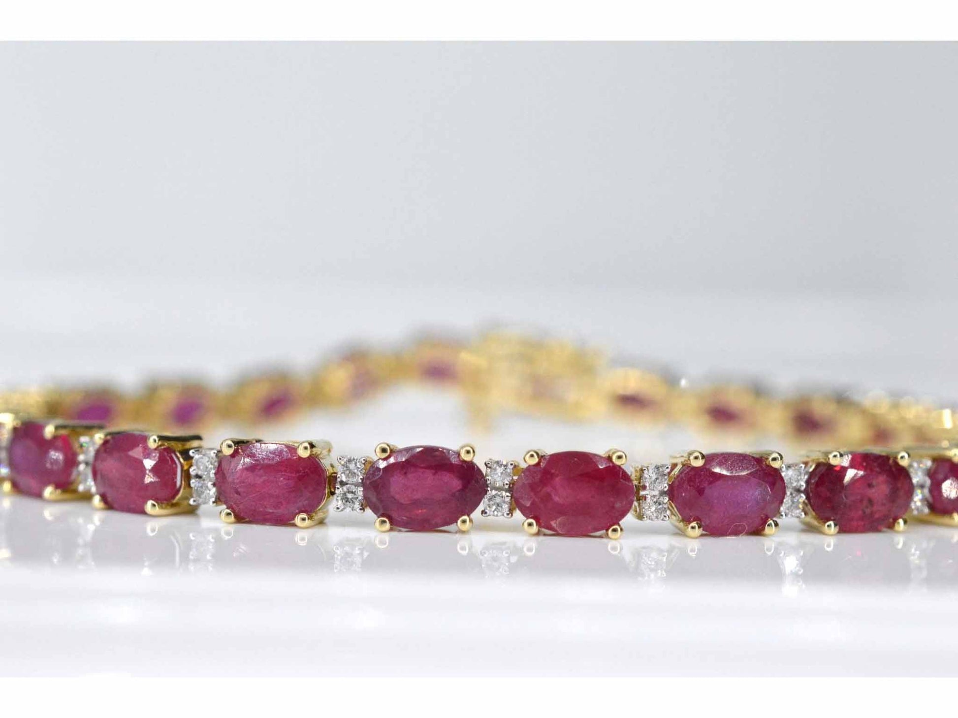 Geelgouden tennisarmband met diamanten en robijn