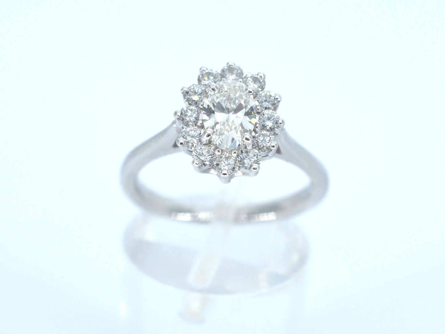 Platina entourage ring met een ovale diamant